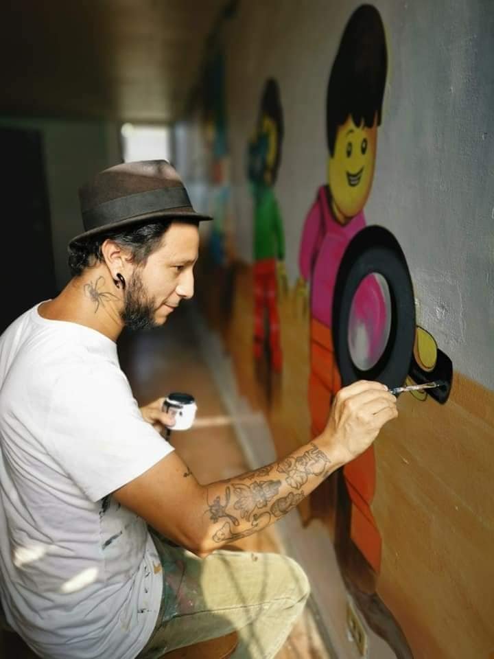 Juan gha el cinco pintando un mural comercial